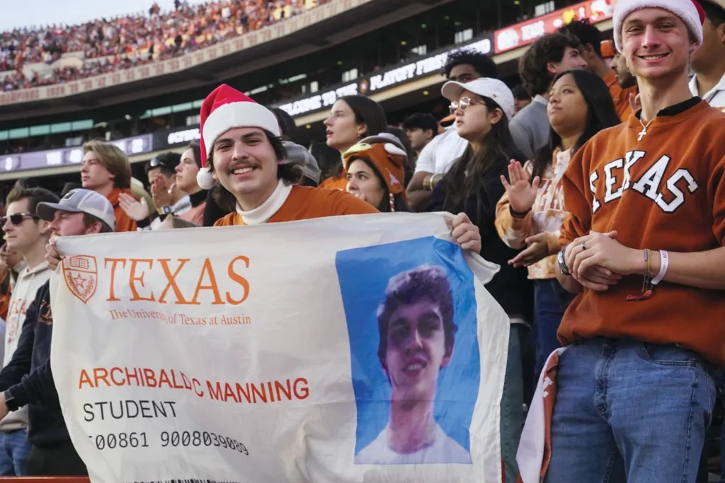 A fan in DKR holds a banner of Arch Manning's student ID.